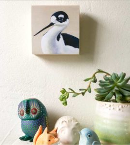 Painting of a black necked stilt by Maggie Hurley hanging on a wall