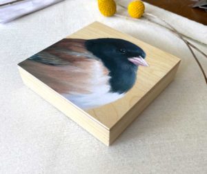 Profile view of painting of a dark eyed junco on wood by Maggie Hurley